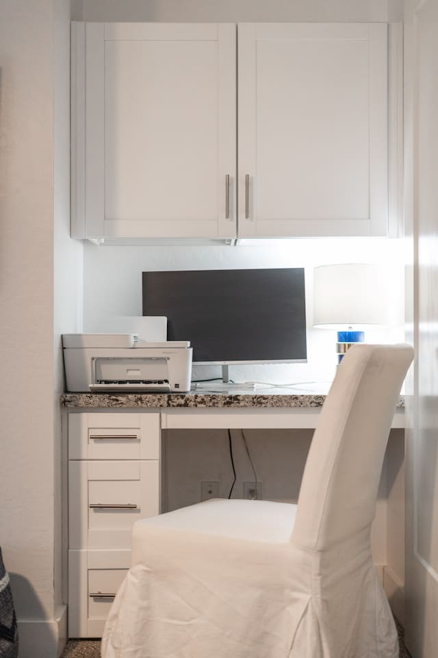 Efficient dedicated workspace with a monitor and printer, designed for productivity and organization.