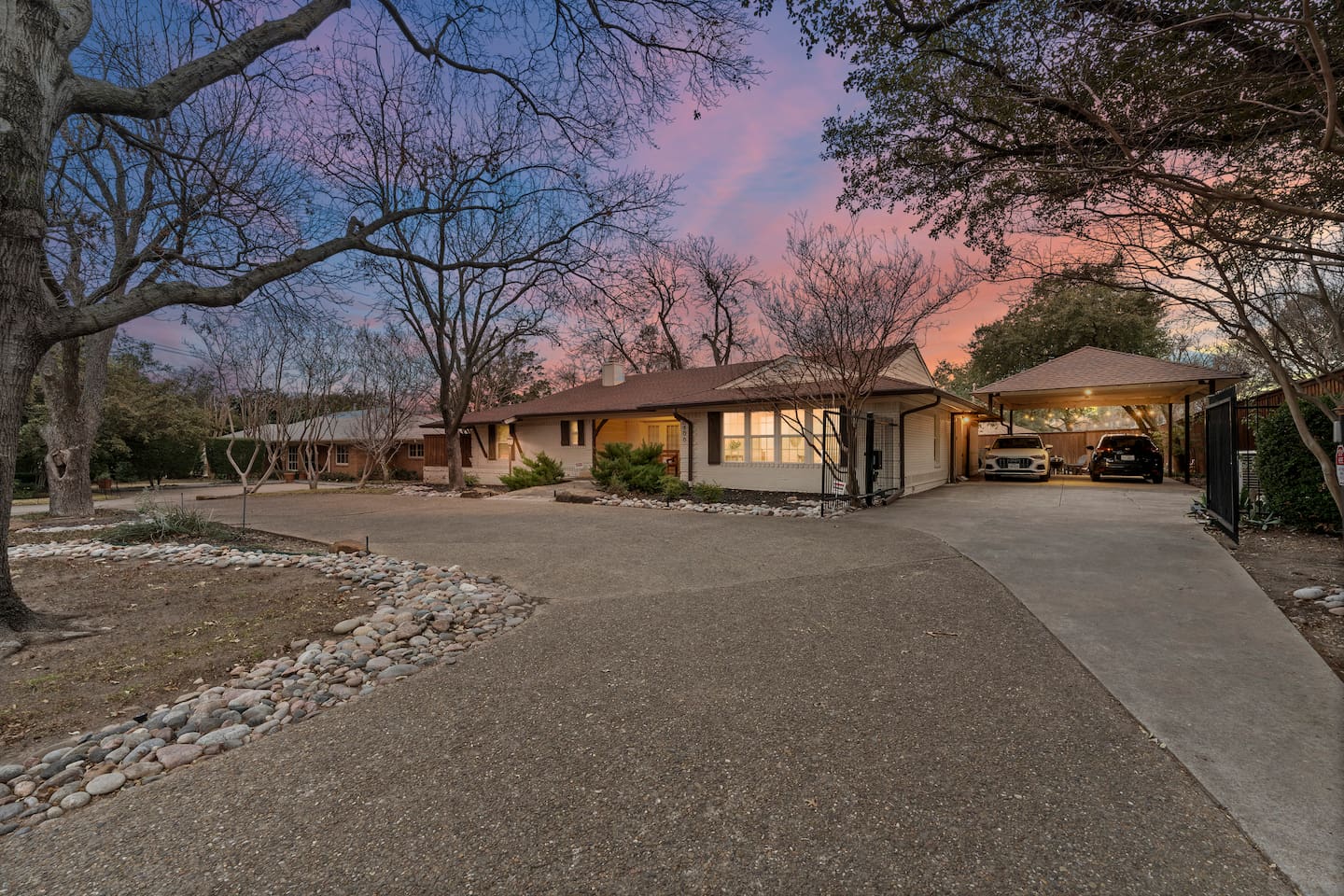 Spacious circular driveway, covered parking, and curb appeal that pops at sunset.