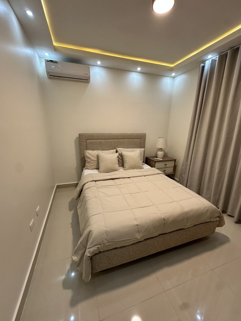 Cozy second bedroom with a queen bed, A/C, warm ambient lighting, and a closet with built-in drawers for storage. 🛏️✨
