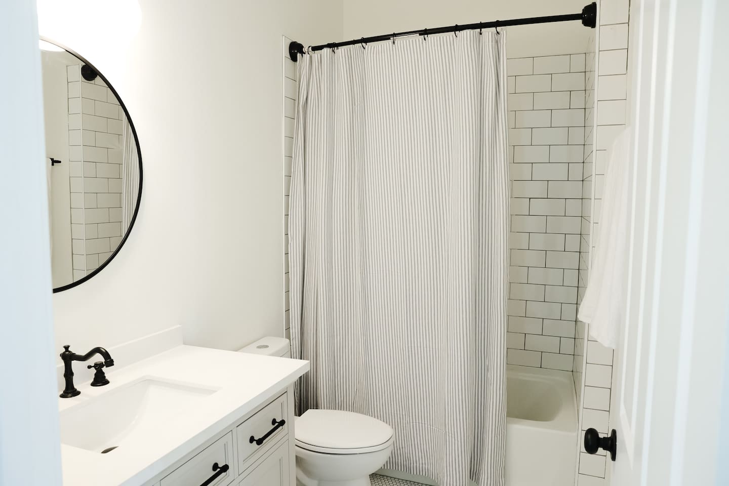 The downstairs full bathroom is just down the hall from the living area featuring a private entrance to the downstairs bedroom.