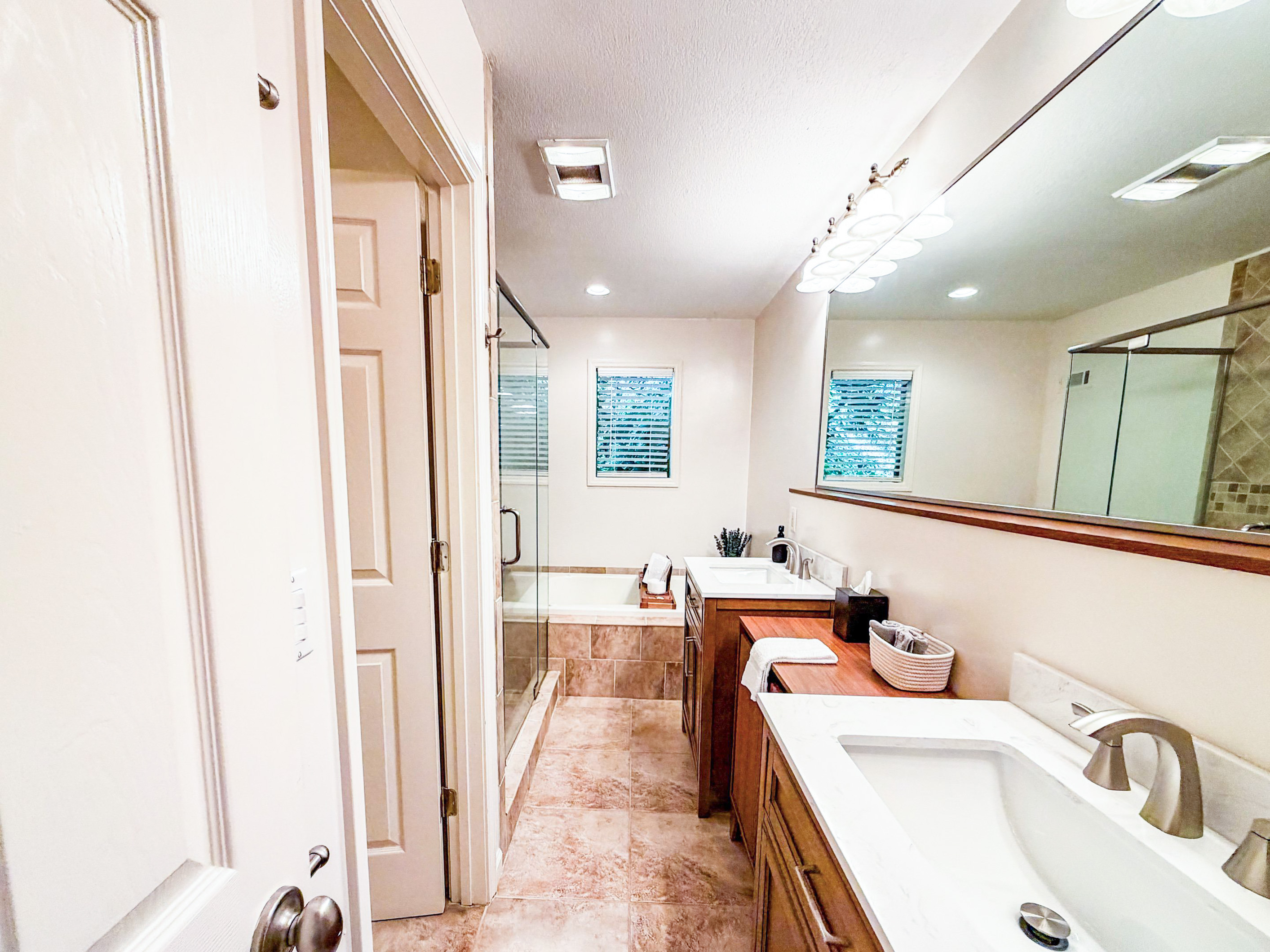 The master en-suite bathroom features dual vanities, a private water closet, a beautifully tiled shower, and a whirlpool tub.