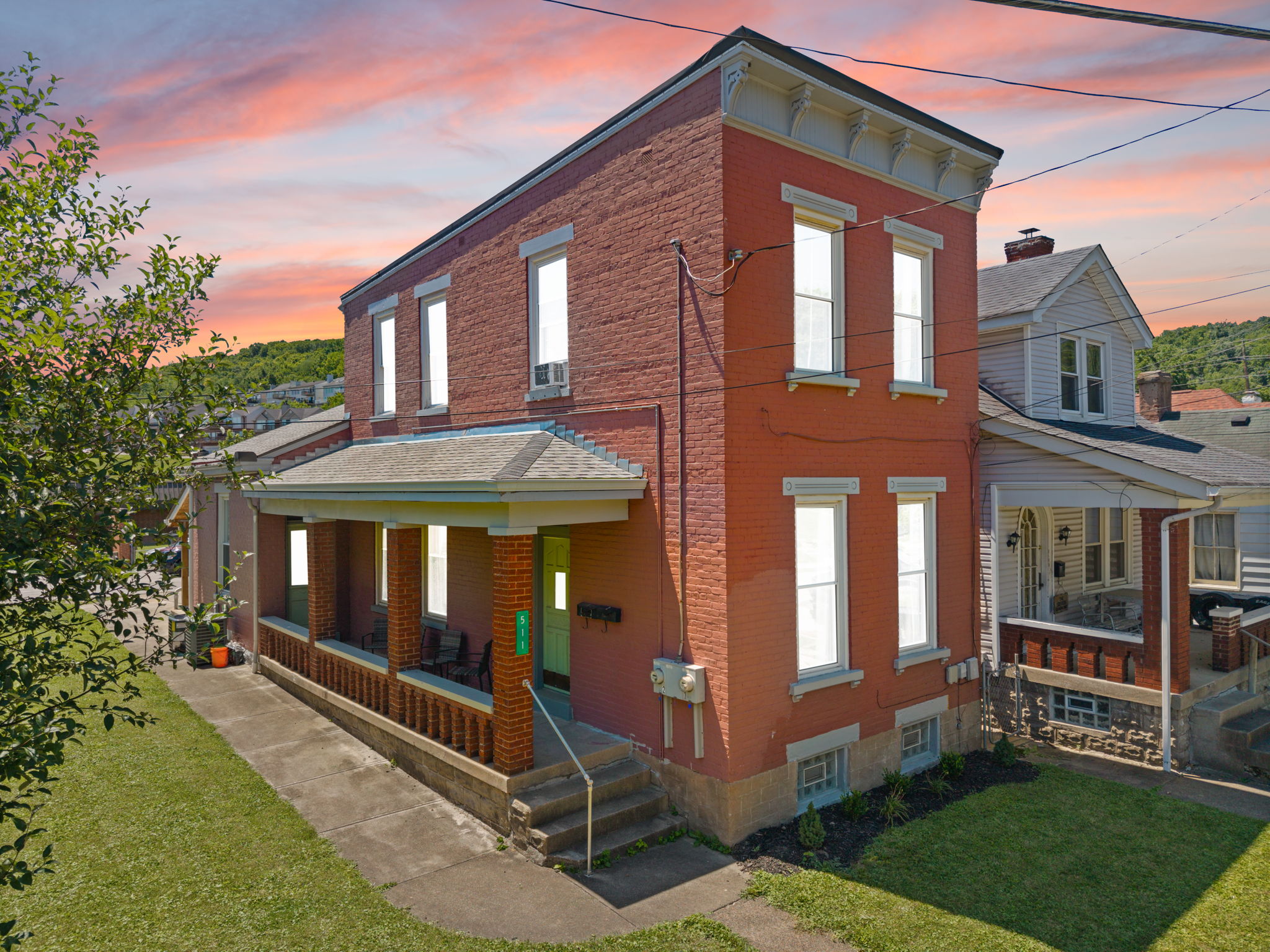 Classic red brick exterior with green lawn and timeless curb appeal