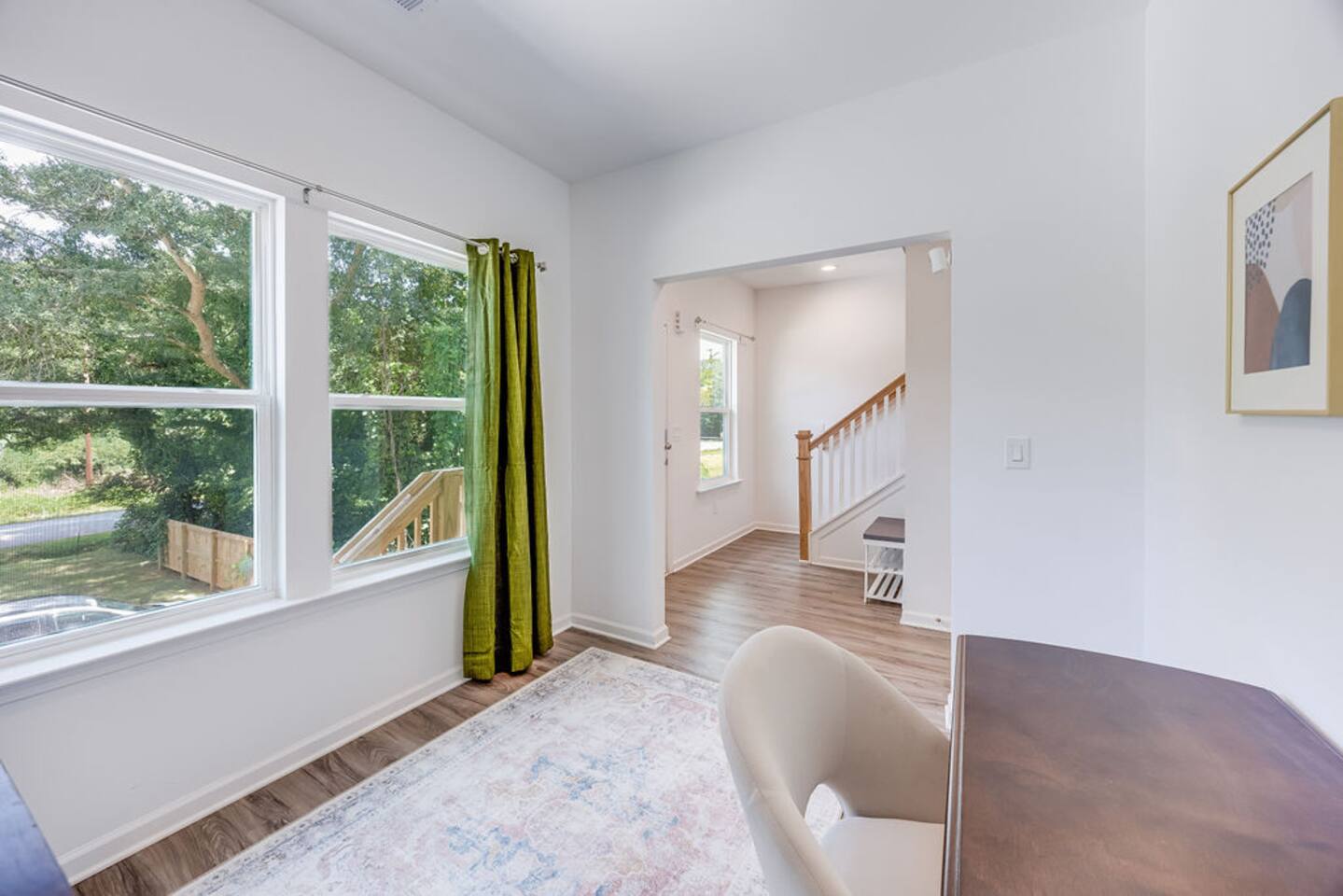 Bright office room with large windows, featuring a Murphy bed that effortlessly folds out into a queen bed, offering versatile space for work or rest.