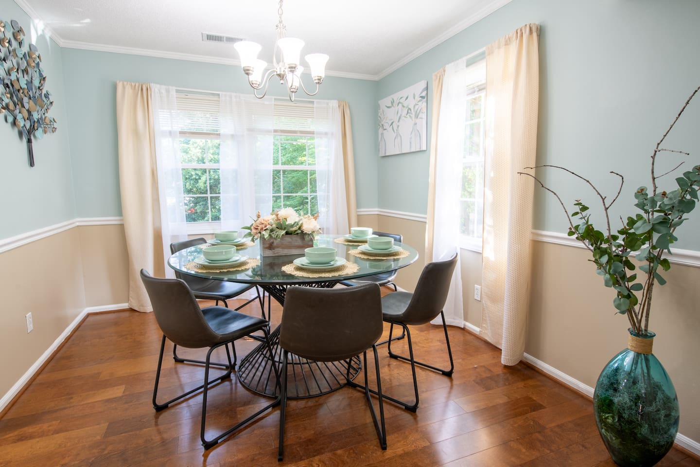 Modern meets cozy in this stylish dining room set for six, with garden views and elegant tableware.