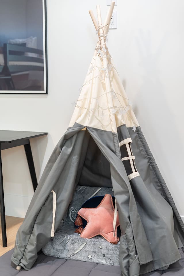 Play tent corner adds a fun, kid-friendly touch to the room.