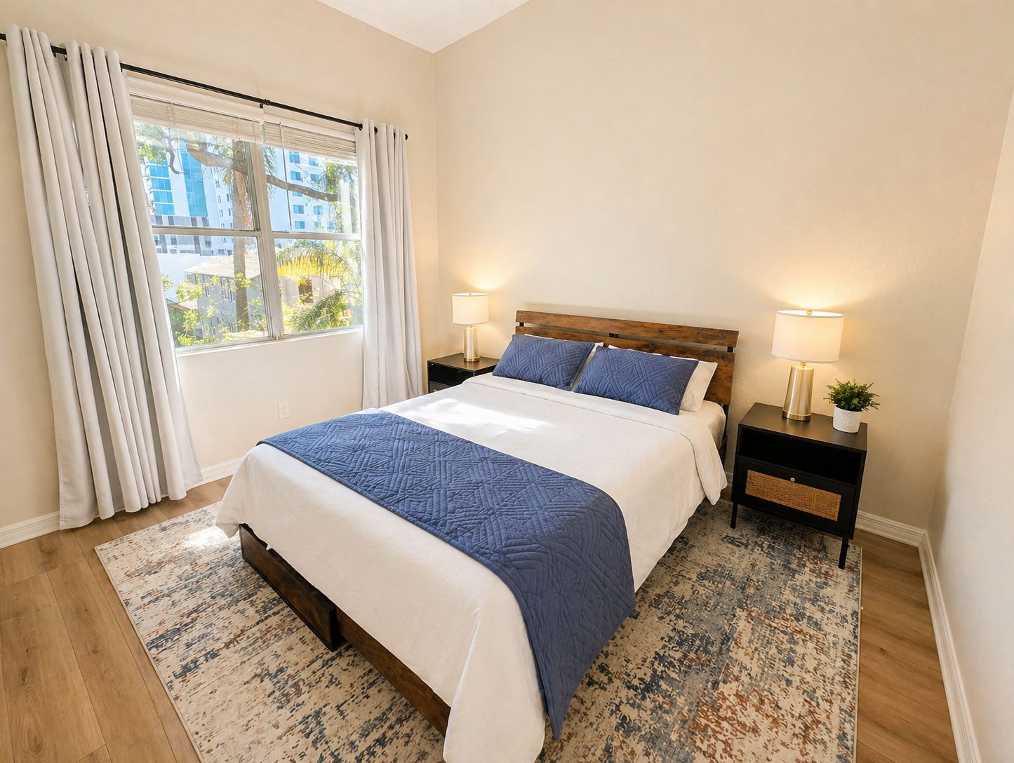 Bright and peaceful bedroom with a comfortable bed, soft linens, and warm wood accents. Large window brings in natural light, while bedside tables and lamps create a cozy, relaxing space for restful nights.