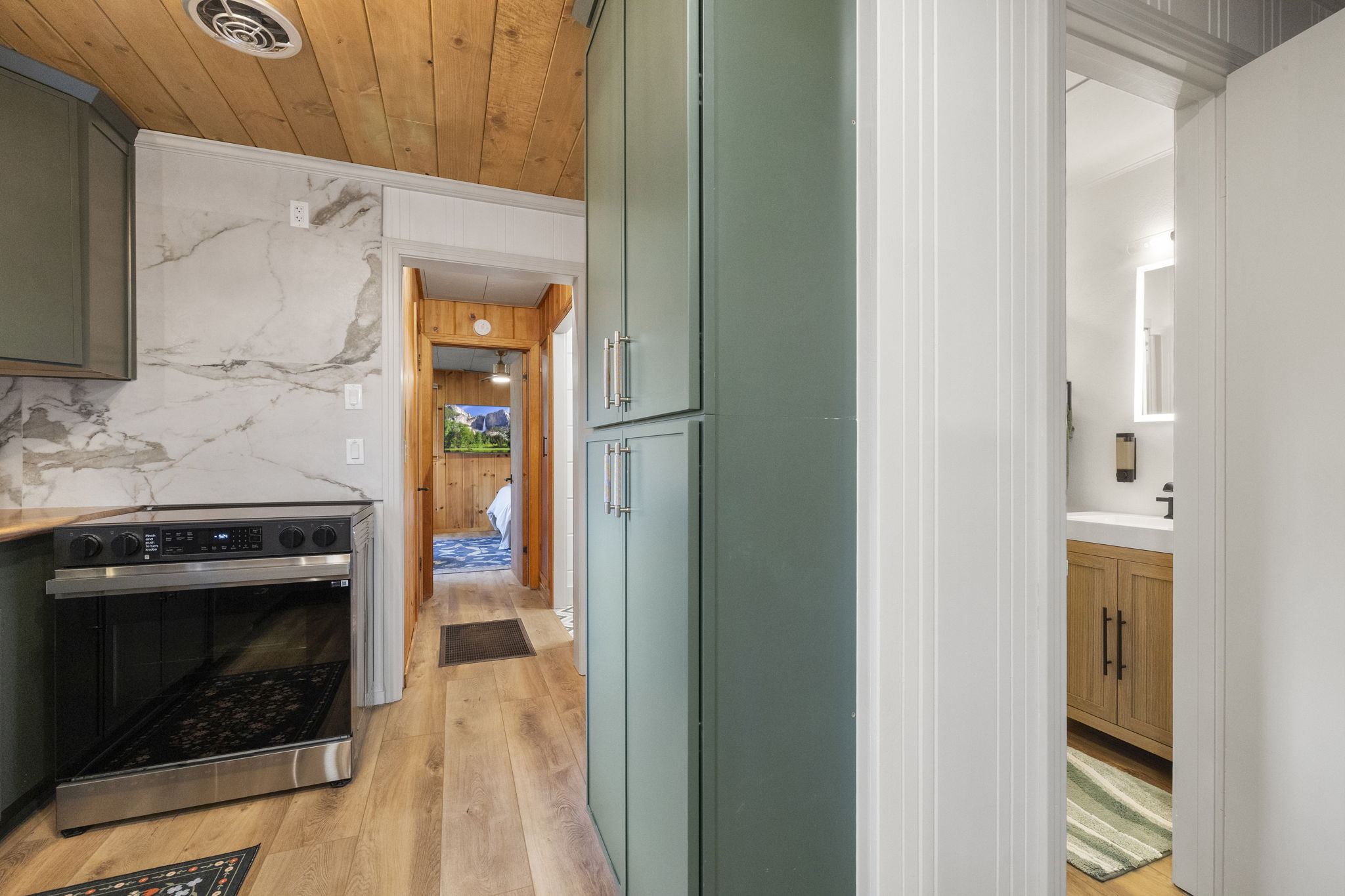 Small hallway off kitchen to the right leads to master bedroom and bathroom. The other hallway leads to the hall bath, mud room and backyard exit and the bunk room.