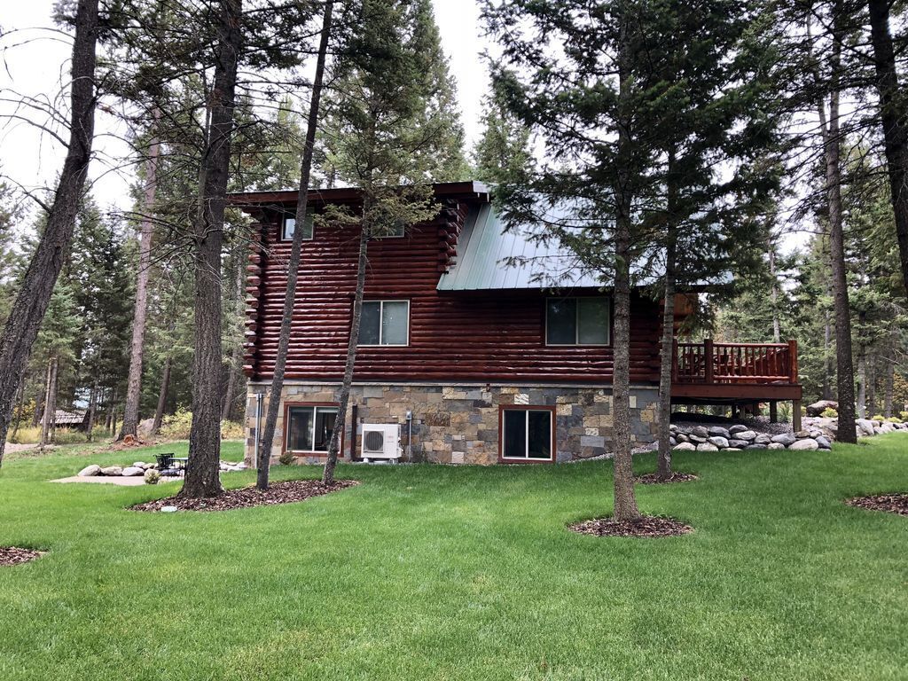 Side view of cabin showing all three stories and lawn for playing games and relaxing.