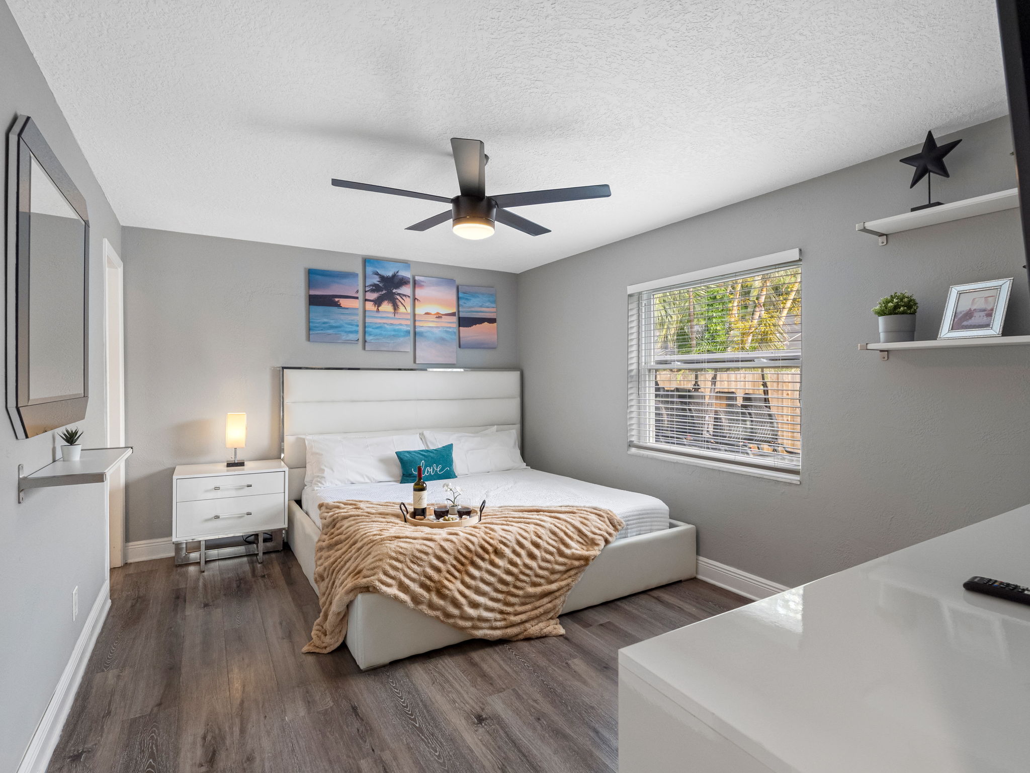 From the plush faux fur throw to the designer headboard and mounted flat-screen TV, every element is thoughtfully selected for comfort and sophistication.