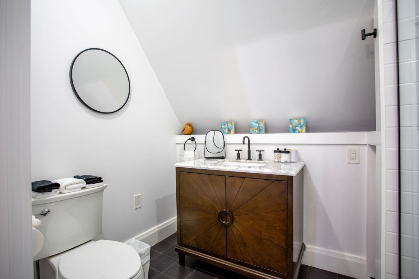 A bathroom featuring a clean, modern toilet, complemented by a stylish cabinet with a sink, offering ample storage space and a sleek design that enhances the functionality and aesthetics of the room.