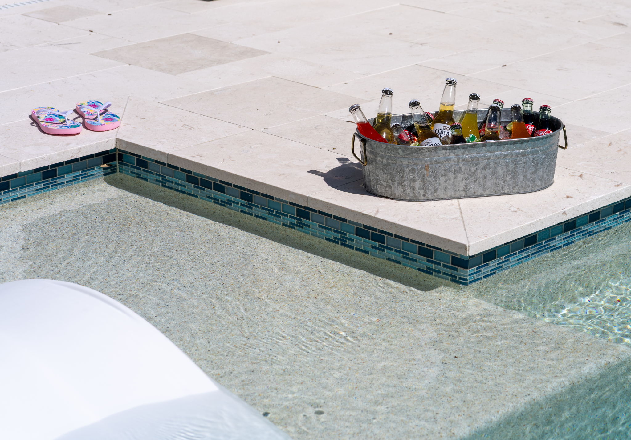 White stone tile, minimalist landscaping, and crisp design make this pool area pop.
