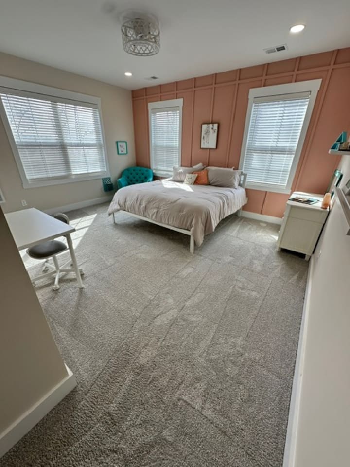 Bright and cheerful, with a super comfy chair for reading and a desk. Private sink and makeup vanity area with access to private toilet and shower rooms, which are shared with bedroom #5. 