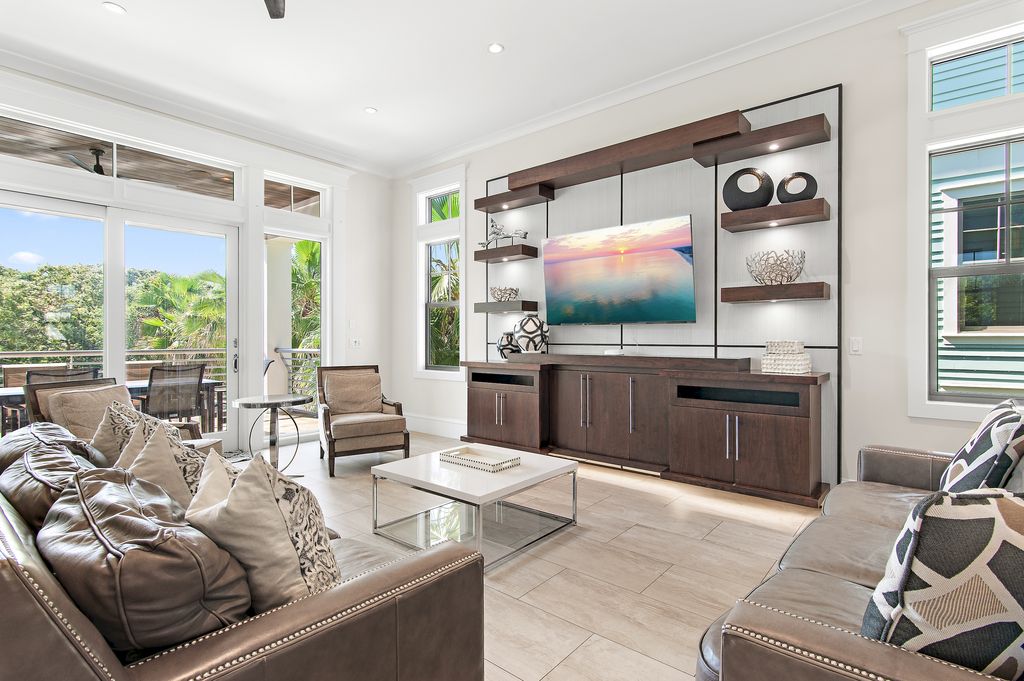Cozy living room with floor-to-ceiling windows and sliding doors opening to the second-floor balcony