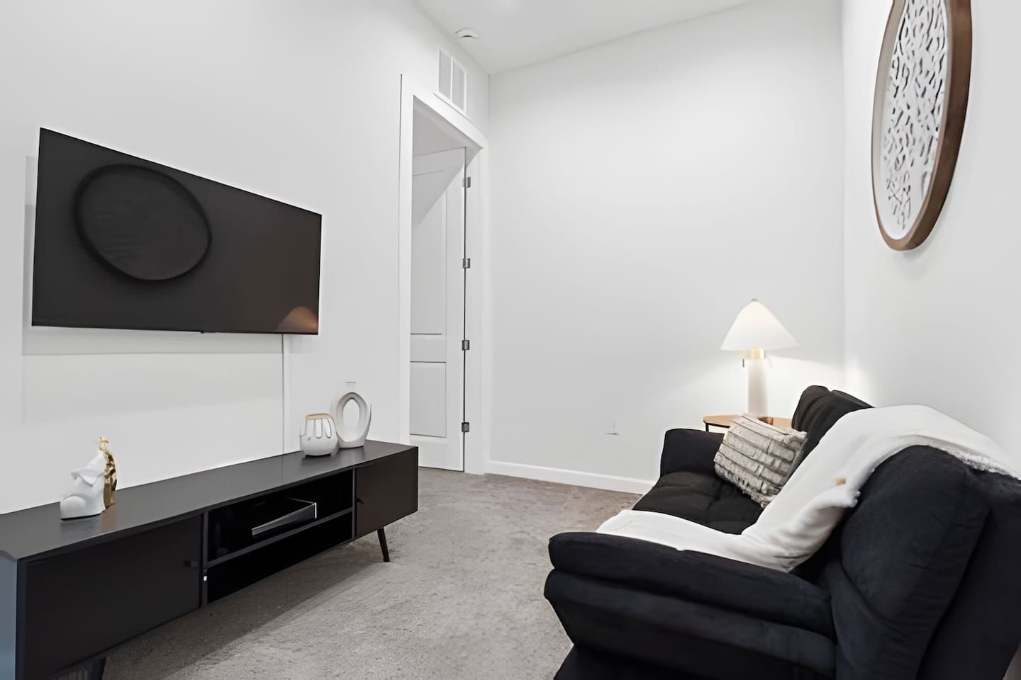 Relax in the spacious living room, complete with a cozy sofa and modern entertainment setup. 