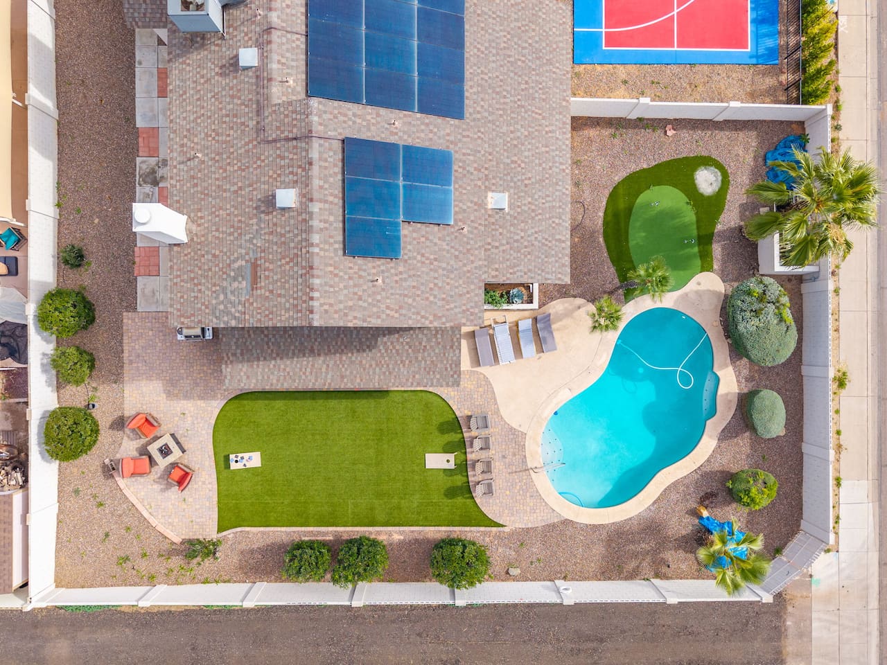 Urban backyard retreat with resort pool, sports court, putting green, and expansive lawn.
