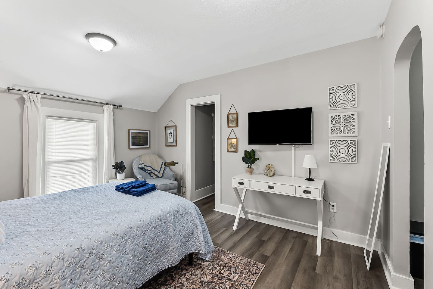 Wind down with a mounted TV and a well-appointed console, all set against warm wood flooring.