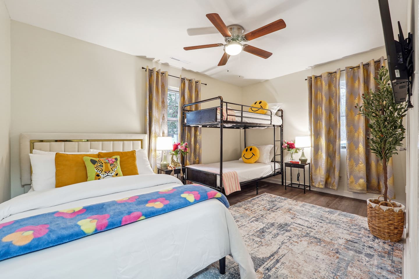 A cozy bedroom featuring a double bed, a bunk bed, a window, a bedside shelf with a lamp, and a TV — perfect for families or groups to relax and unwind.
