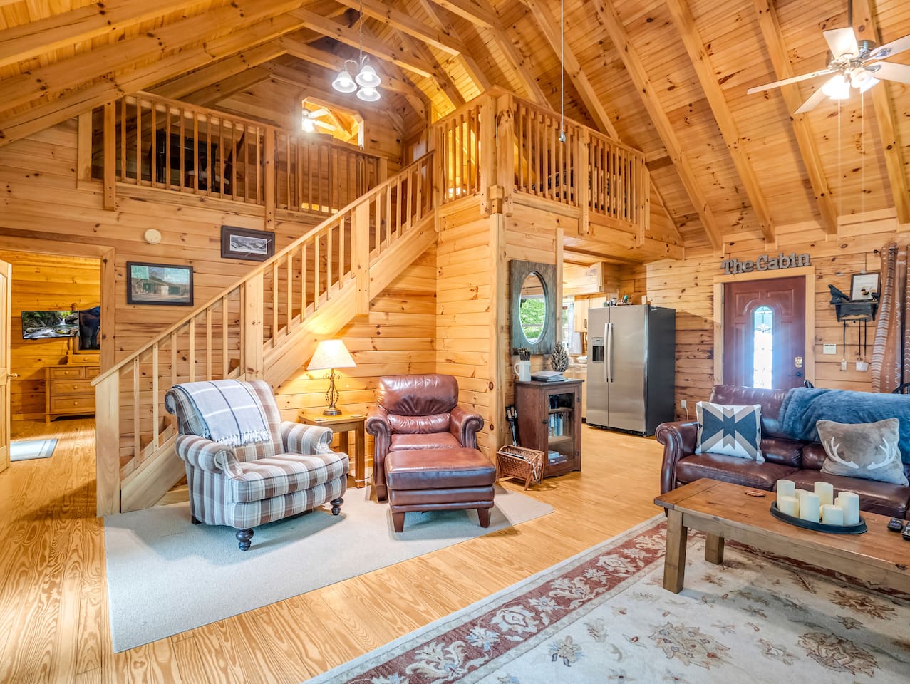 Inviting reading nook and seating area beneath the staircase leading to the third level of the cabin