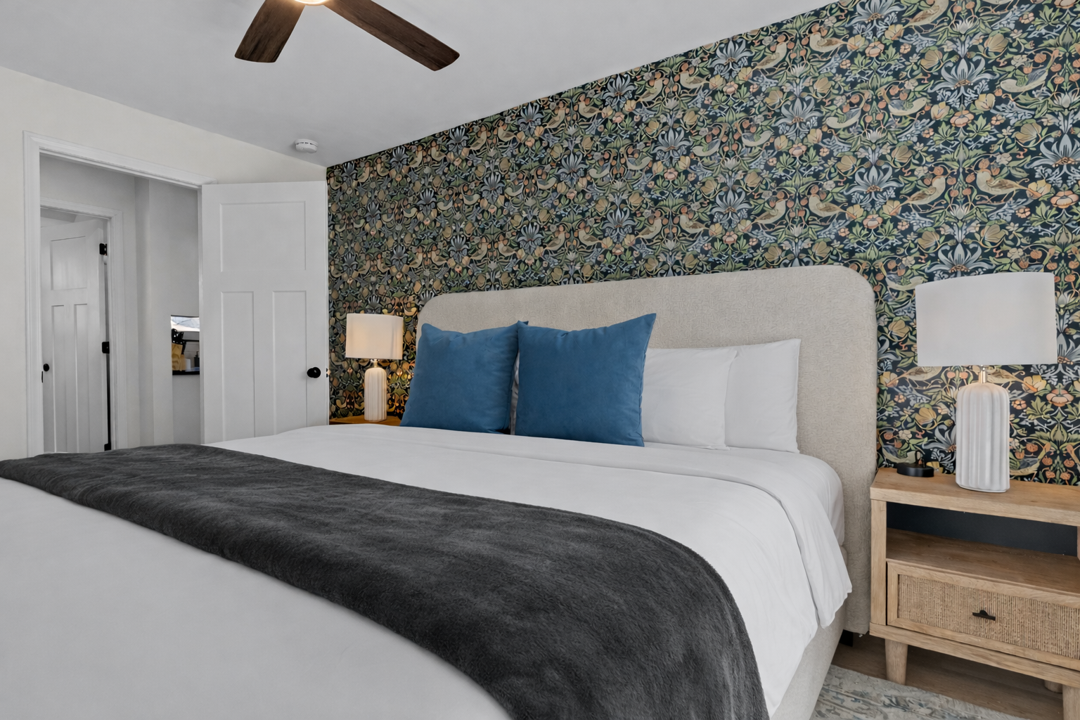 Comfortable, thoughtfully designed bedroom with a plush bed, ceiling fan, soft lighting, and a stylish accent wall for a relaxing retreat.