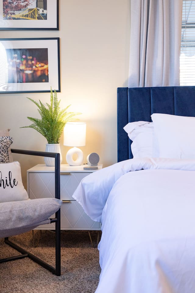 Cozy, spacious room with a queen-sized bed, TV, and a dedicated working space.