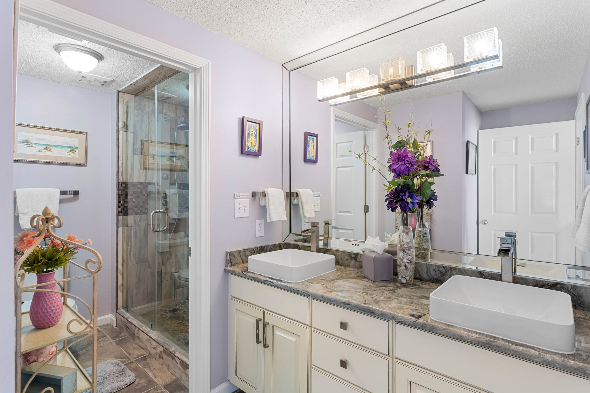 Bathroom vanity w/ large mirror, clean lines & simple coastal style.