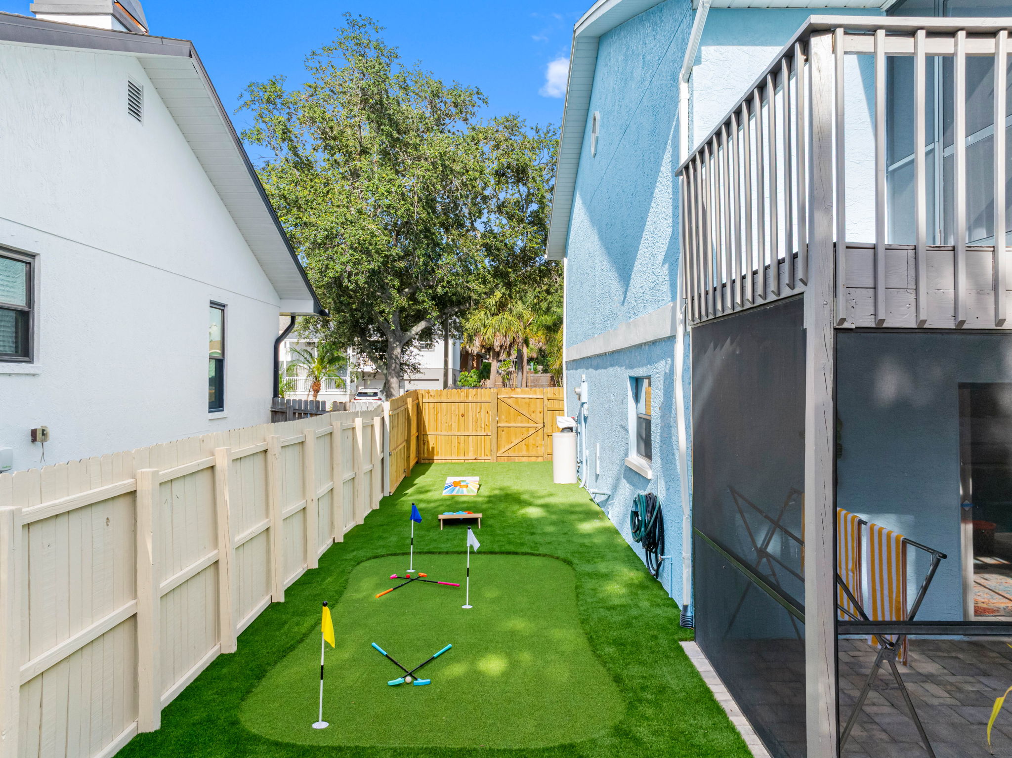 With a colorful cornhole set and putting green just steps from the patio, this fenced-in yard offers endless entertainment without leaving home.