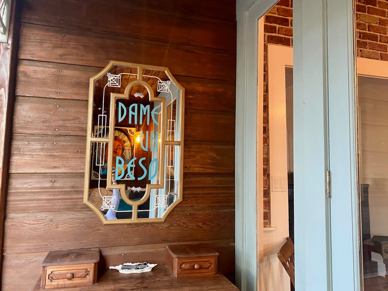 Dame un beso —give me a kiss. A forgotten art deco-ish mirror repurposed:  reimagined by a local Los Alamos artist, who also created the Kissing Cove installation it reflects.  