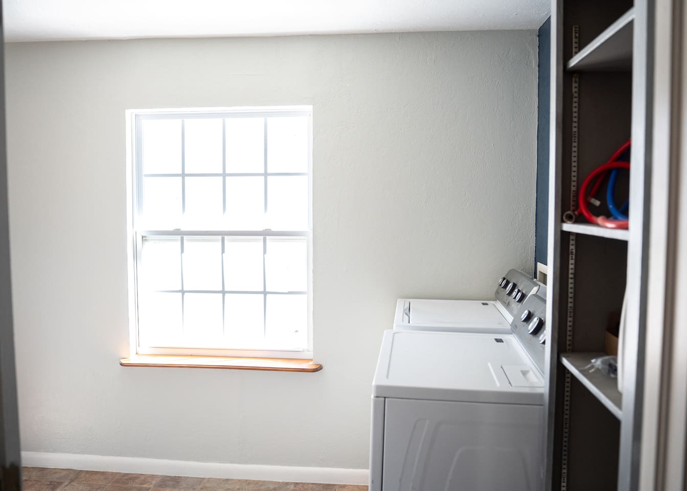 Laundry room equipped with full-size washer and dryer.