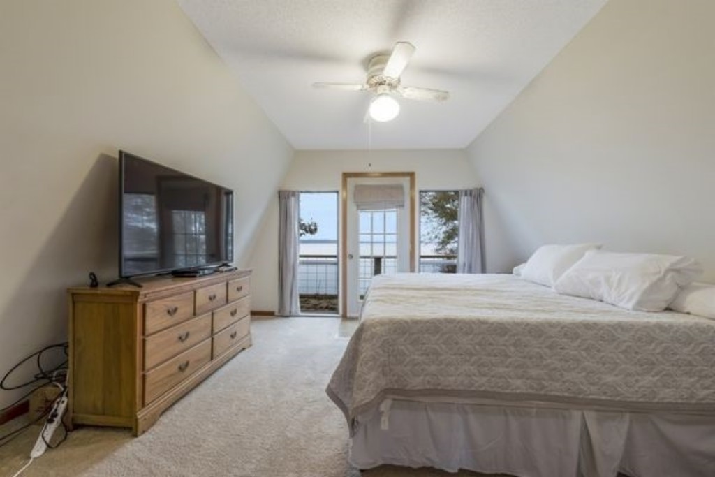Guest Bedroom 2, located upstairs, offers a comfortable queen-size bed in a cozy and inviting space—perfect for a restful night's sleep or a quiet retreat during your stay at Larkspur Lodge. 