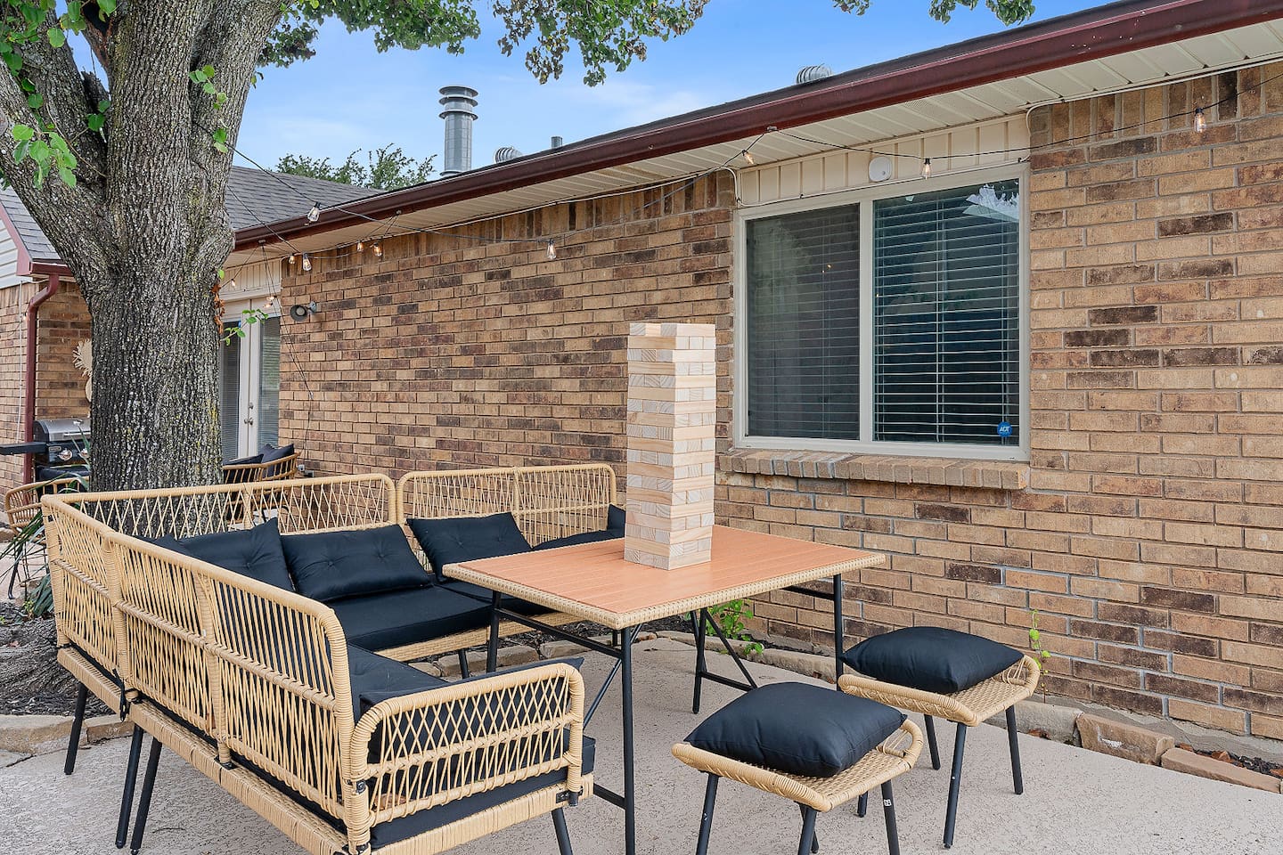 Gather around the outdoor seating area for games and socializing. The space is designed for comfort and enjoyment.