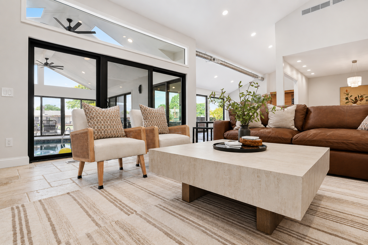 Relax in the bright and inviting living area, featuring comfortable seating, modern design, and seamless access to the indoor pool and outdoor spaces.