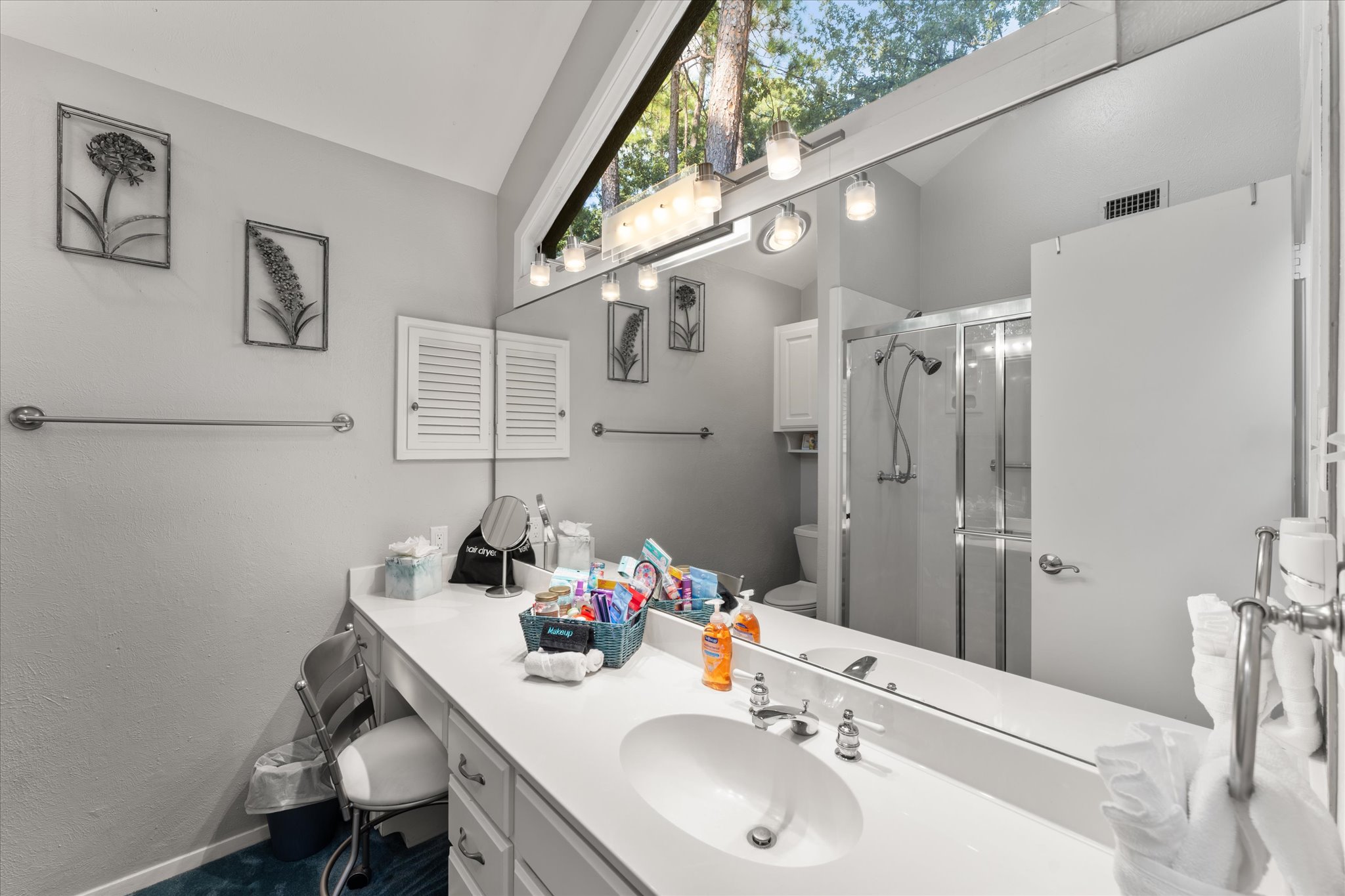 King 2 Bathroom features a walk-in shower, a thoughtful basket filled with essentials, and stunning views through its unique, eye-catching windows.