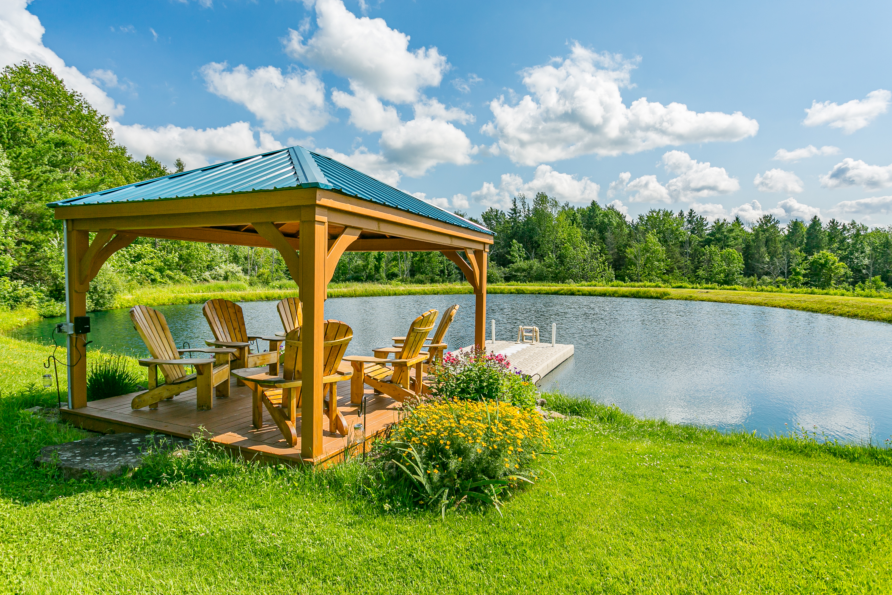 Gather with friends and family beneath a rustic pavilion by the pond, complete with classic Adirondack chairs and picture-perfect views.