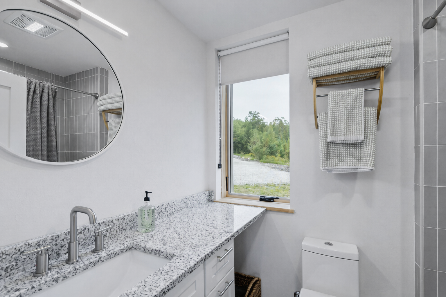 The first floor full bathroom features a modern tiled shower/bath combo.