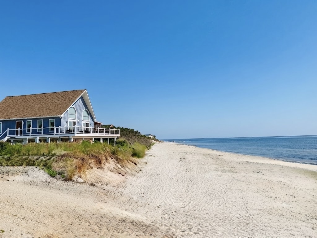 Enjoy the perfect beachfront escape at this stunning property, uniquely positioned for direct shoreline access and sweeping coastal views from its expansive elevated deck.