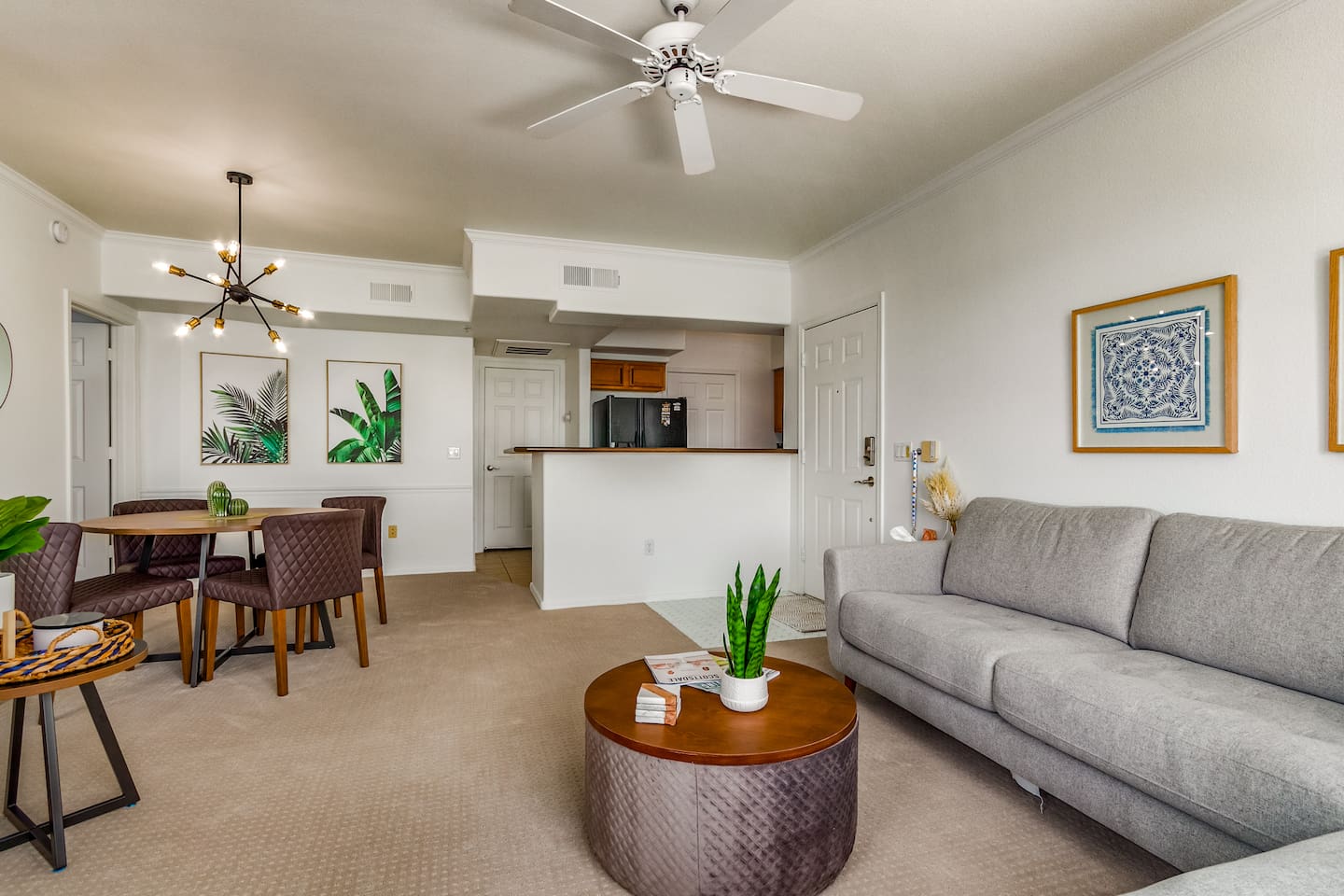 Living room with sectional seating, kitchen and dining area overview