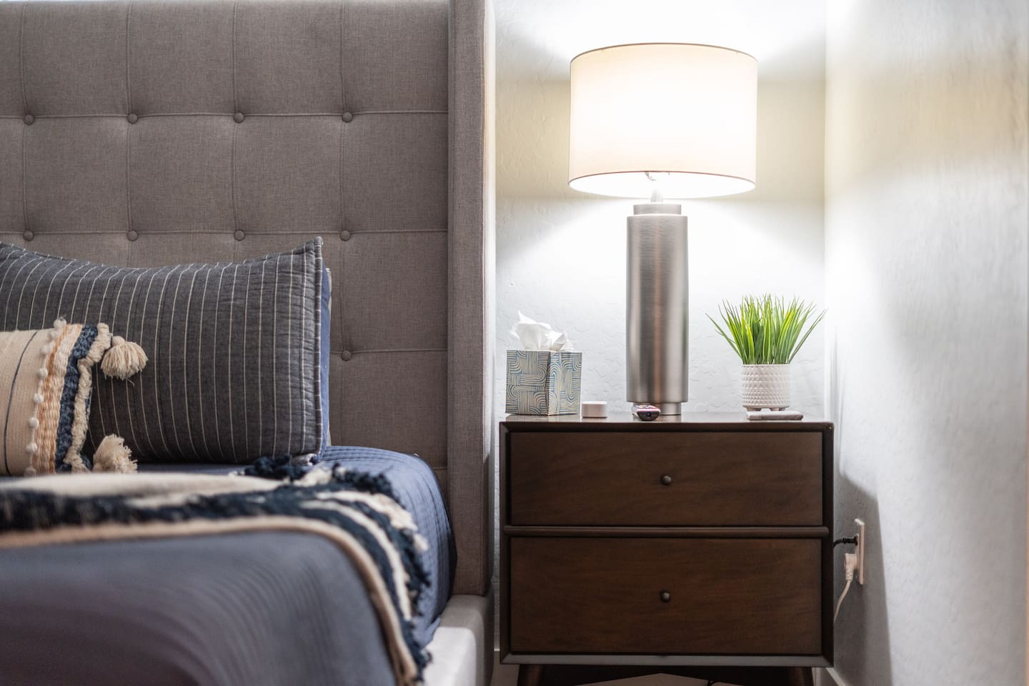 Chic bedside table with a stylish lamp, providing both function and ambiance to your bedroom.