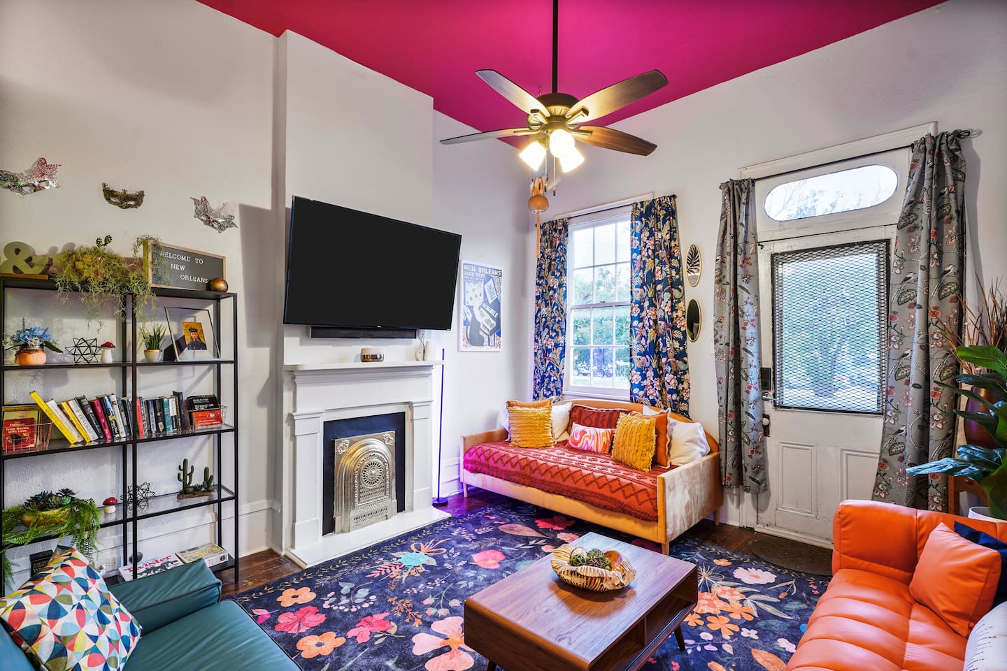 Your bright, colorful living room has cozy seating, a twin daybed, a 65" Roku TV with sound bar, and vibrant decor.