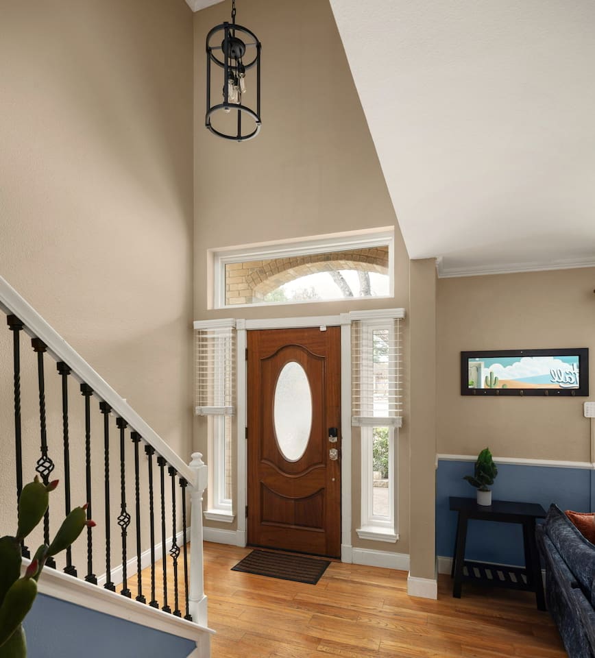 Stylish front entry with warm natural light, elegant staircase, and welcoming design—your perfect first impression upon arrival