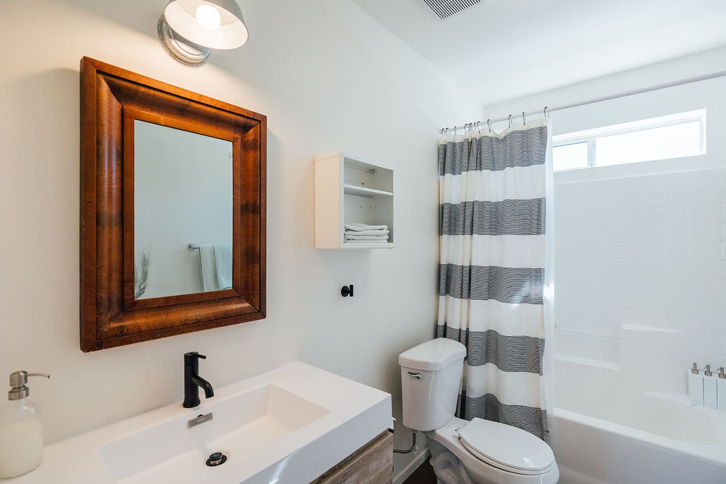 Third Bathroom: Minimal bathroom with bathtub and space for personal items. Accessible from main community areas (dining room/living room).