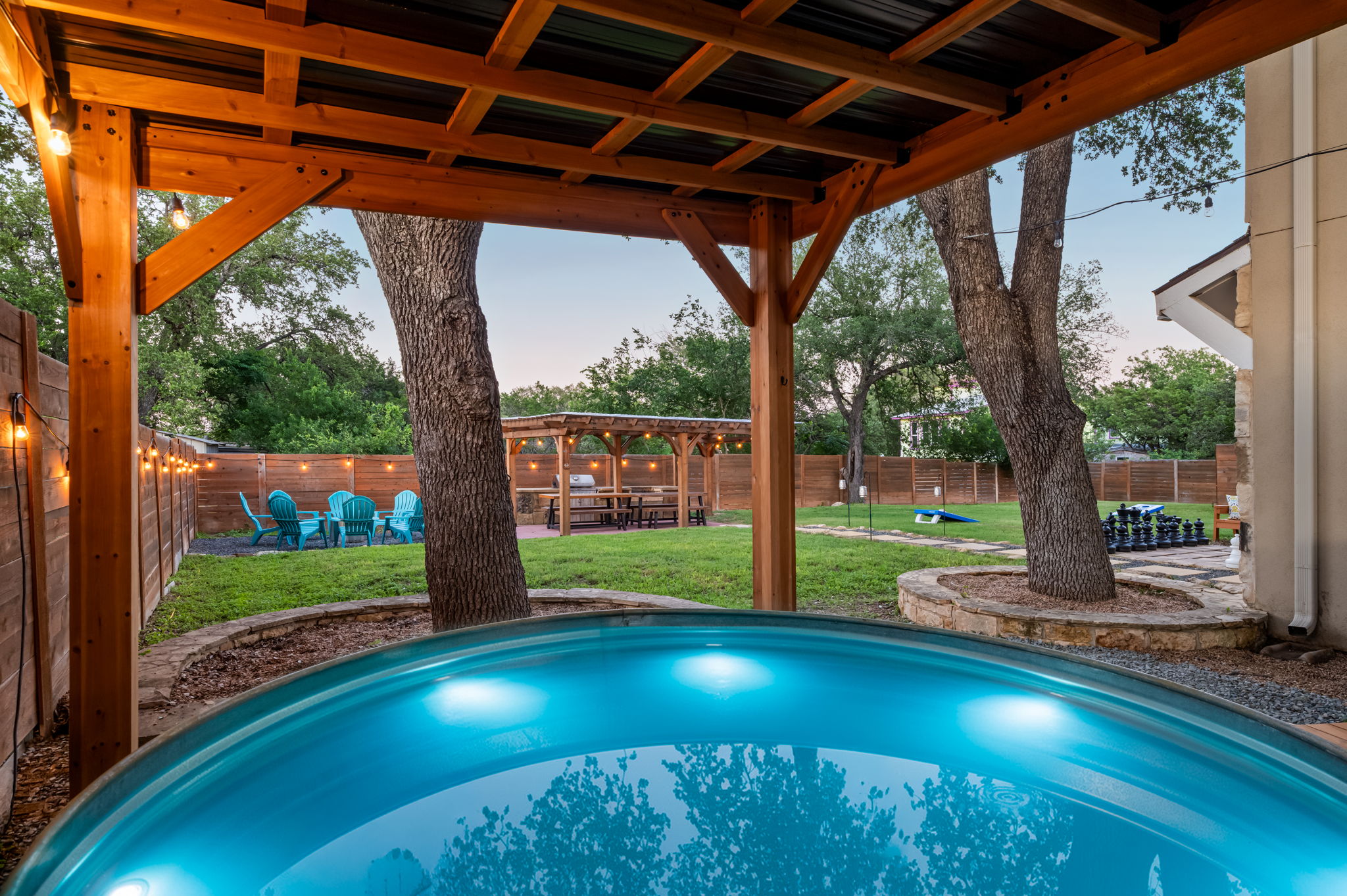 Cool off in the unique cowboy pool tucked beneath a covered lounge area with string lights and backyard views. A fun and relaxing spot to unwind after BBQs, games, and outdoor adventures.