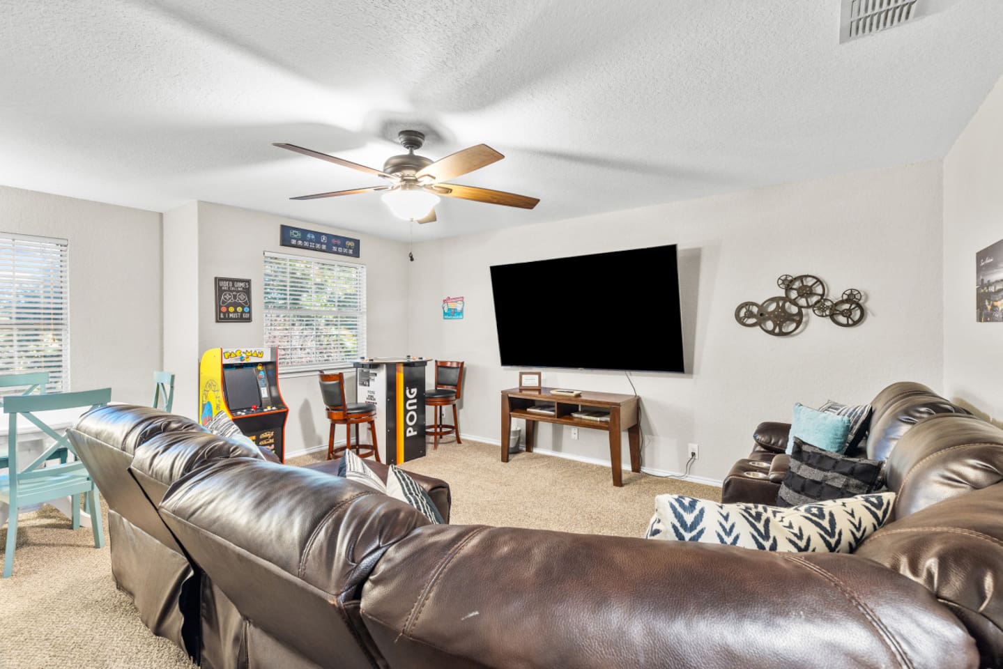 Private cinema and game room featuring a large-screen HD setup, surround sound, and classic Pac-Man arcade for nonstop entertainment.