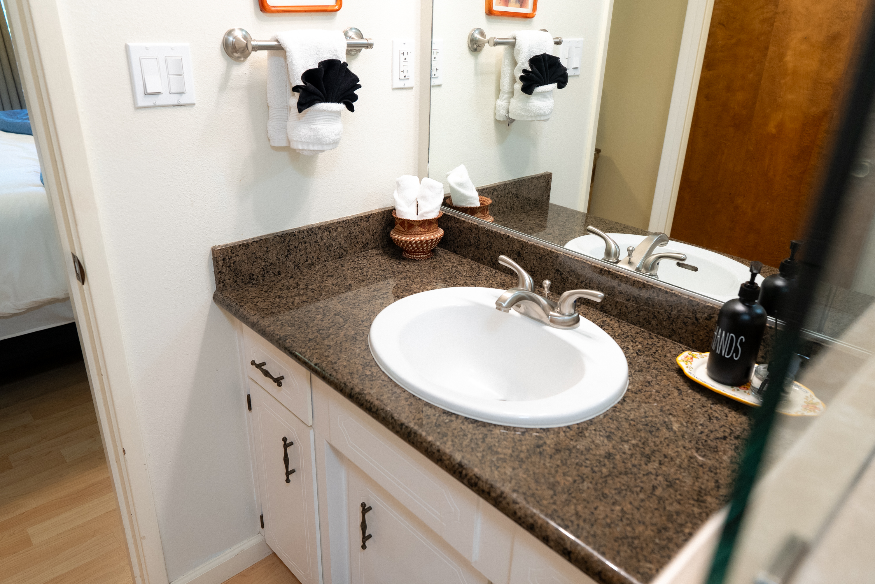 An organized vanity and soft linens for spa-like comfort.