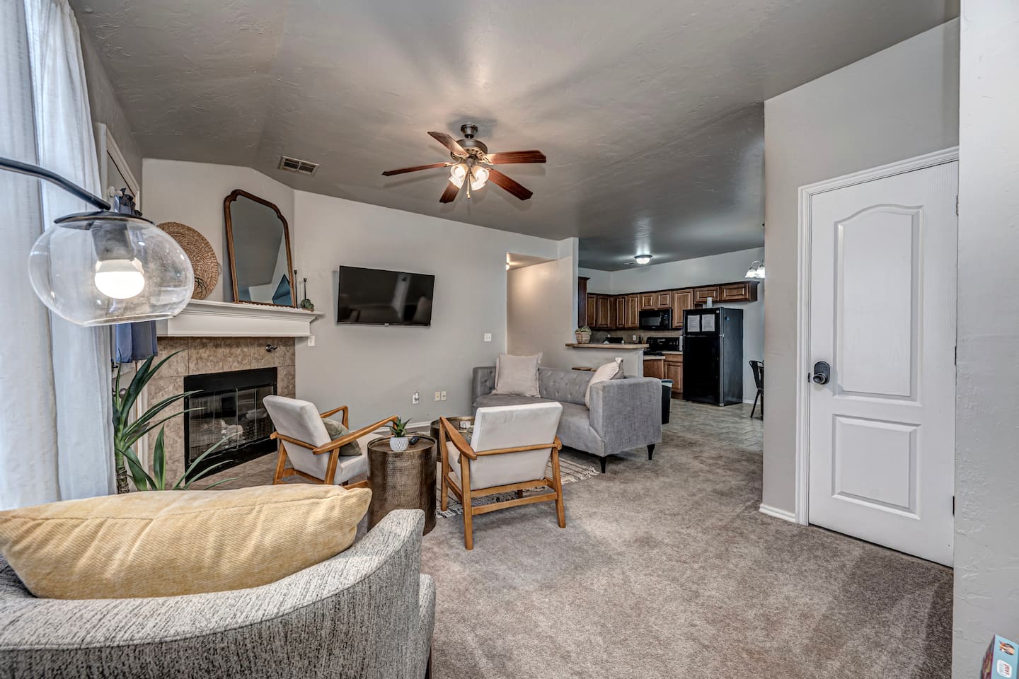Spacious living area featuring comfortable seating, smart TV, and a warm fireplace.