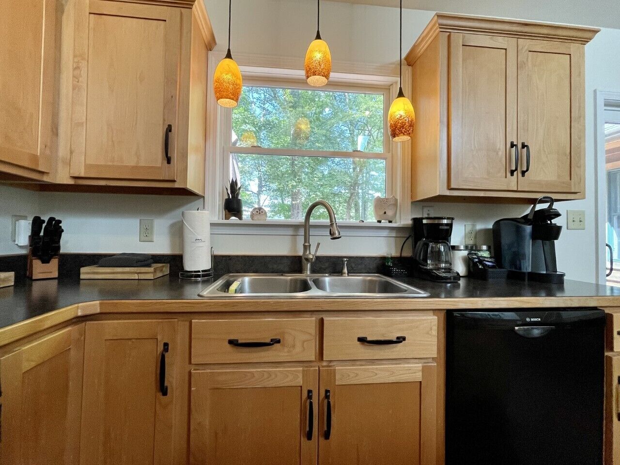 Kitchen sink with a window view of the back deck and beyond