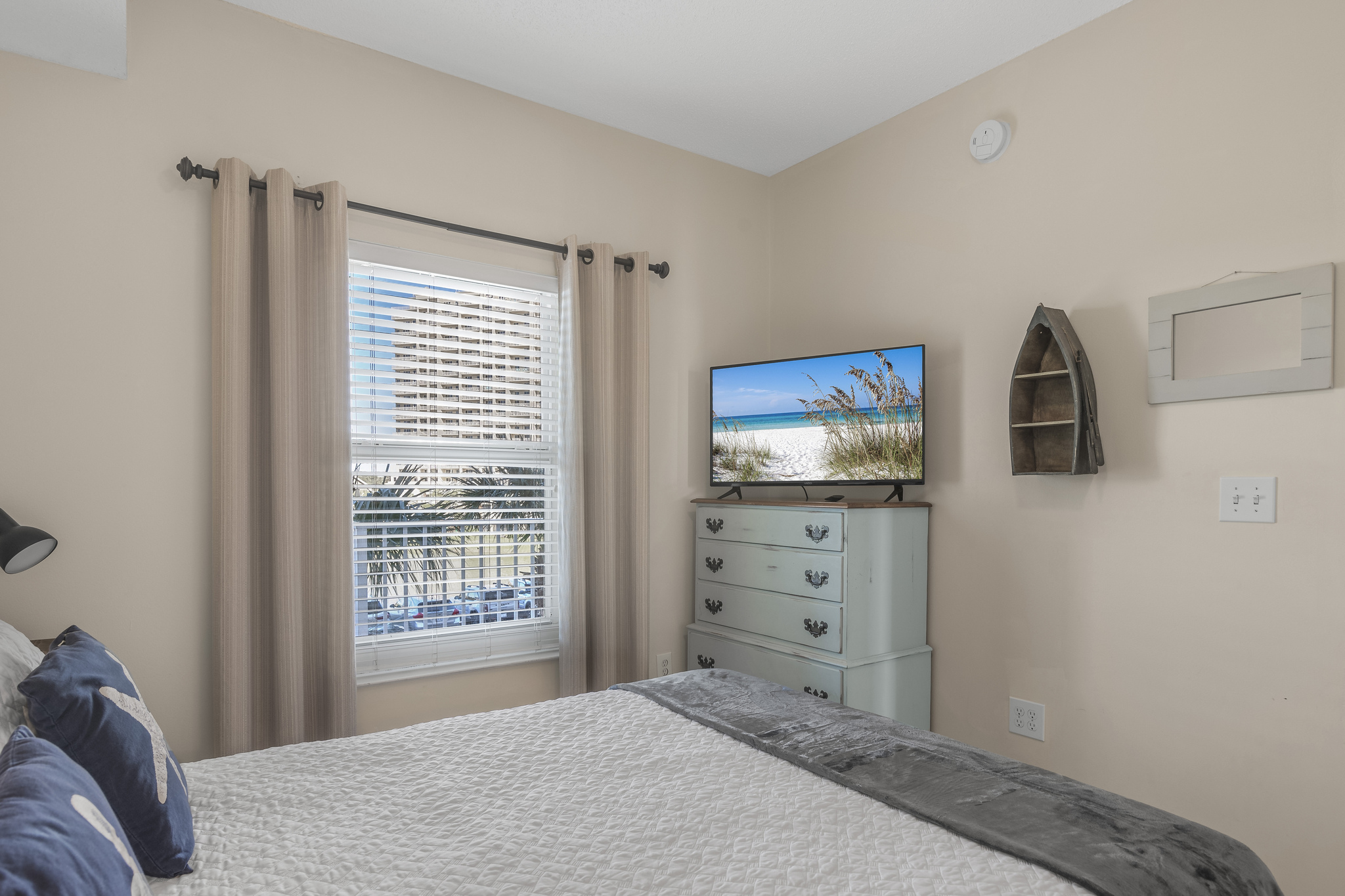 Secondary bedroom with Queen bed, flat screen TV, beachy decor, and private bath