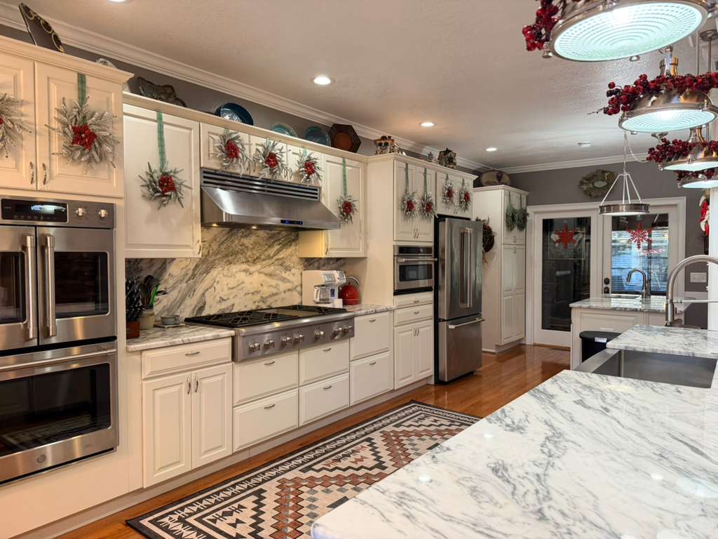The Gourmet Heart of the Home: Our Chef's Kitchen is decorated for the holidays! Features professional GE Cafe appliances, double ovens, and ample marble counter space for preparing your festive feast.