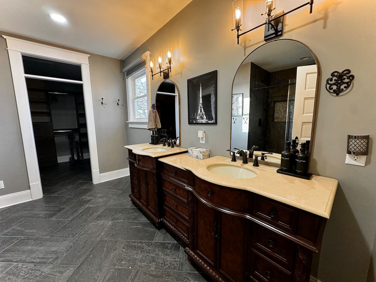 Double vanity in large Paris ensuite bathroom connects to oversized walk-in closet with built-ins.