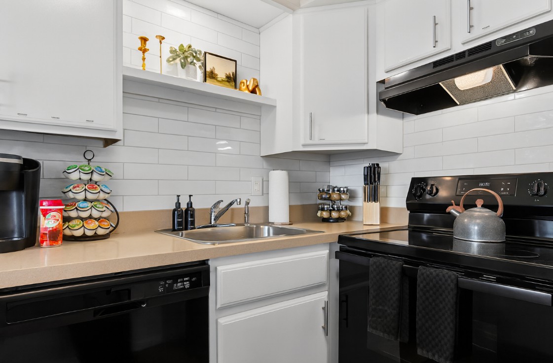 Sleek and modern kitchen, granite countertops, and a coffee station.