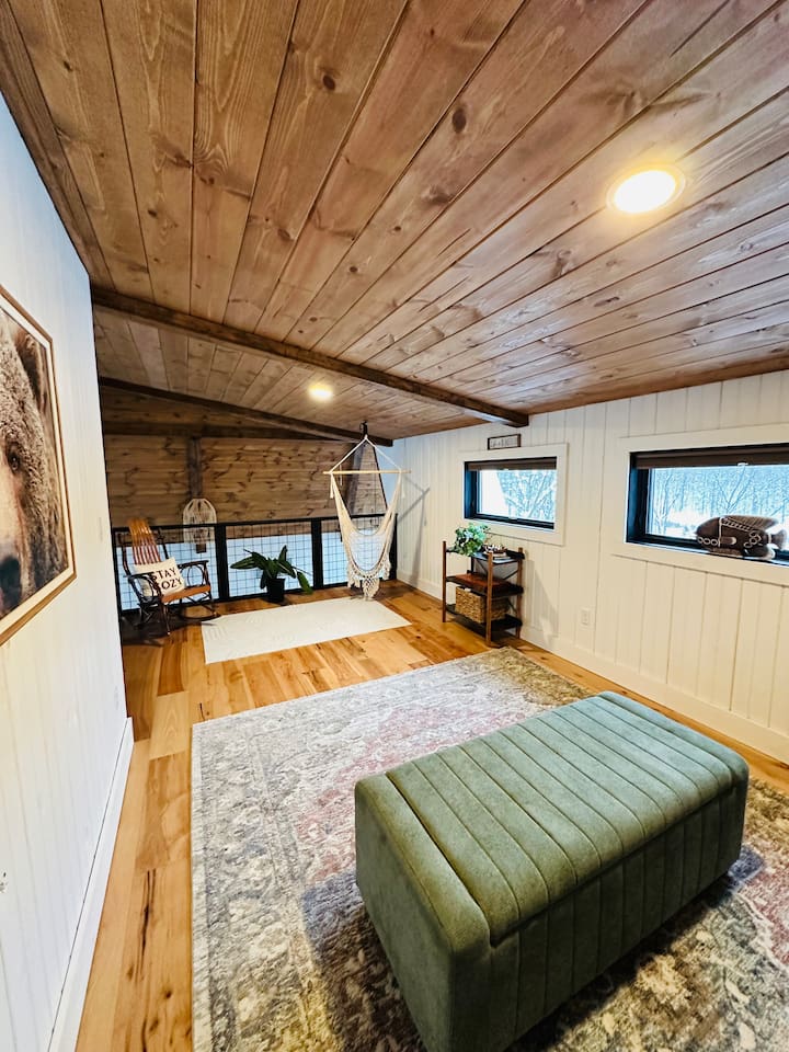 This cozy, open loft features a comfortable queen pullout sofa bed, perfect for two people. The loft overlooks the living room, offering a unique blend of privacy and openness, ideal for those who enjoy a spacious and airy living environment.